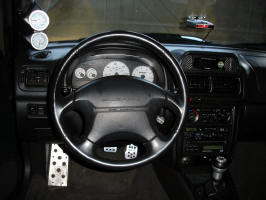 Interior. Front top left to bottom right: Greddy Boost/EGT gauges, Escort Passport 8500 radar detector, Apexi S-AFC2, Sparco race pedals and dead pedal, MOMO shift knob, Carbon fiber trim.